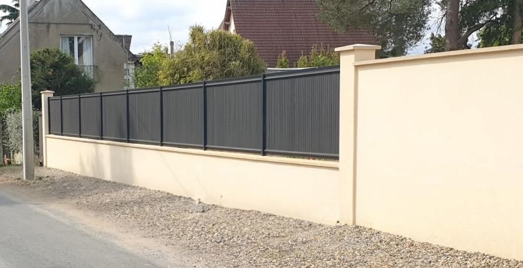 Une maison blanche avec une porte de garage blanche et une jardinière sur le côté.