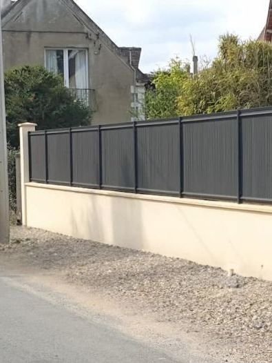 Un mur blanc est en train d’être construit au milieu d’un champ de terre.